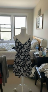 Amateur cell phone shot of black floral dress on mannequin